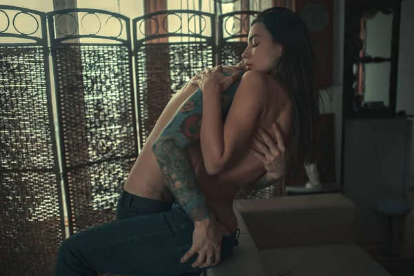 Tutku uyum içinde aşk ön sevişme sırasında hugs karanlık odada genç Çift.