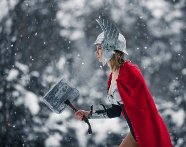 Fırtına ve gök gürültüsü Germen-İskandinav tanrısı görüntü kadın elinde çekiç ile gider. Cosplay.