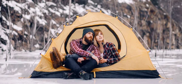 Jeune couple assis dans une tente pendant la randonnée hivernale . — Photo