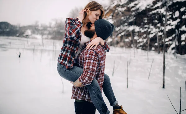 Genç çift hugs ve öper kış yürüyüş sırasında. — Stok fotoğraf