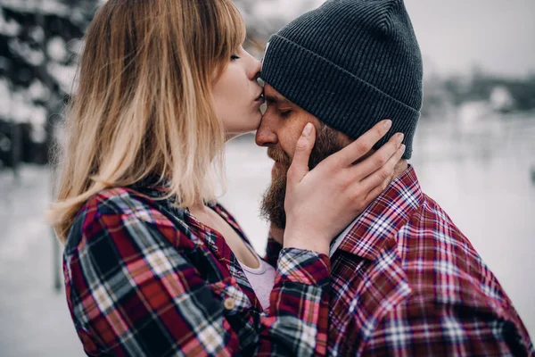 Meisje kussen jongen tijdens winter wandeling. — Stockfoto