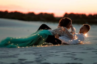 Gelin ve damat çölde ampulleri Garland'a sonraki gün batımında yalan..