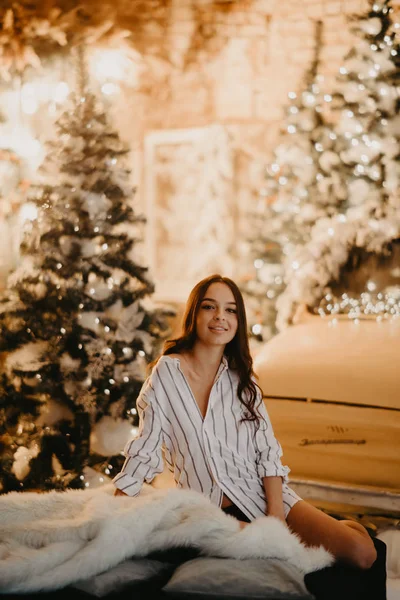 Mulher bonita senta-se contra fundo de decorações de Natal e — Fotografia de Stock