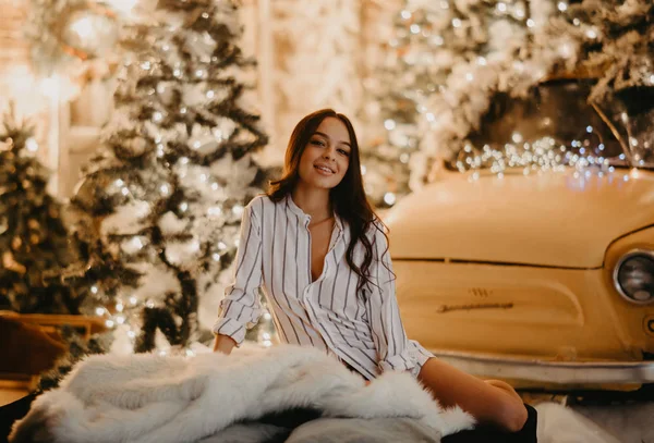 예쁜 여자가 크리스마스 장식의 배경에 둘러앉아서 — 스톡 사진