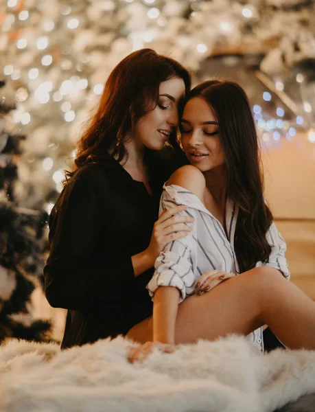 Pareja de lesbianas se sienta en el fondo de las decoraciones de Navidad . — Foto de Stock