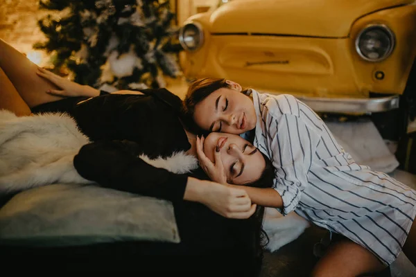 Lesbian couple lies against background of Christmas decorations — Stock Photo, Image