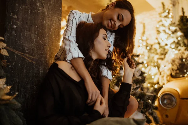Leszbikus pár ölelés háttér karácsonyi dekorációk — Stock Fotó