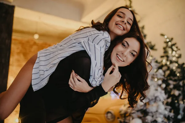 Lesbianas pareja tiene un divertido contra fondo de Navidad decorat —  Fotos de Stock