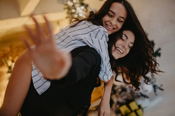 Lésbicas casal tem uma diversão contra o fundo da decoração de Natal — Fotografia de Stock