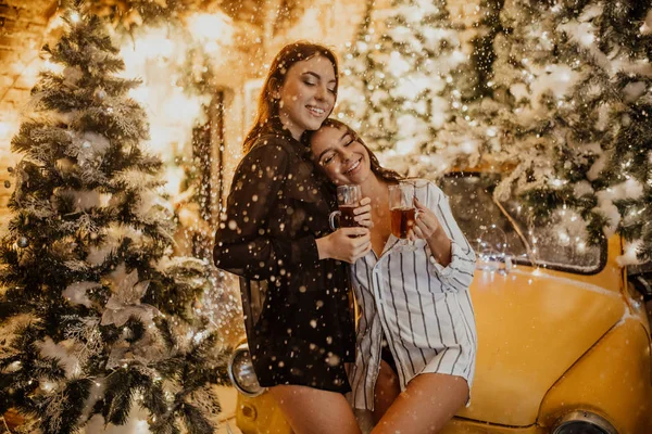 Lesbiskt par håller glas vin mot bakgrund av Chris — Stockfoto
