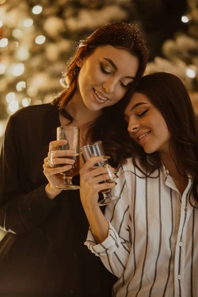 Lesbijki para trzyma kieliszki wina na tle Chris — Zdjęcie stockowe