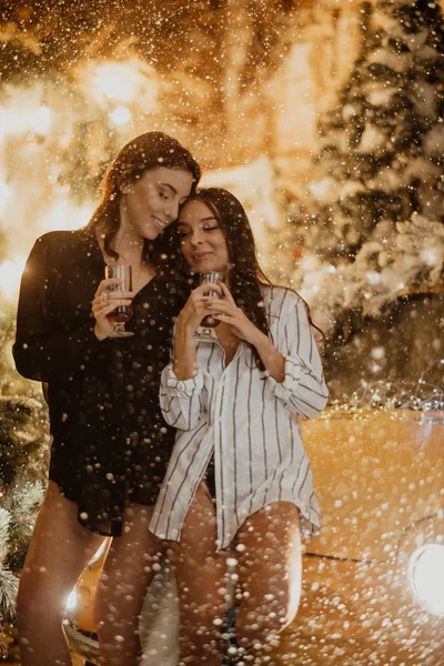 Lesbičky pár drží sklenice vína na pozadí Chris — Stock fotografie