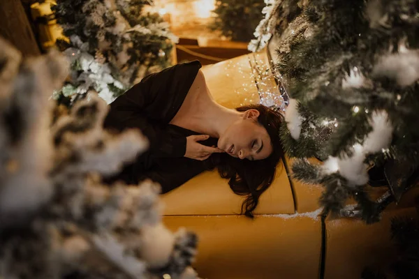 Ładna kobieta leży na retro samochód na tle Bożego Narodzenia d — Zdjęcie stockowe