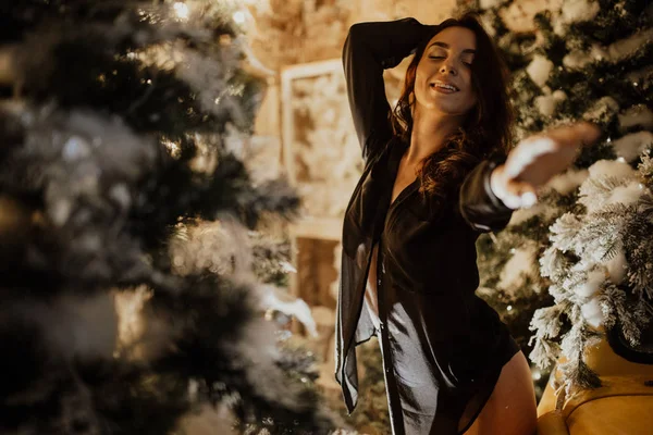 Güzel bir kadın Noel süslemelerinin arkasında duruyor. — Stok fotoğraf