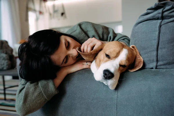 Egy nő és egy kutya fekszik a kanapén és alszik.. — Stock Fotó