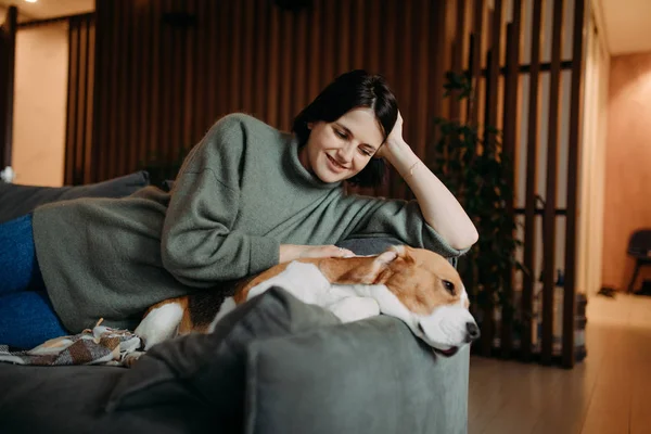 Eine Frau liegt neben einem Hund und umarmt ihn. — Stockfoto