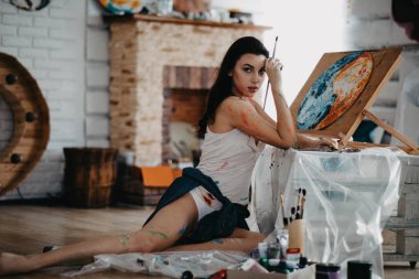 Sanatçı bir sanat atölyesinde resim çizer..