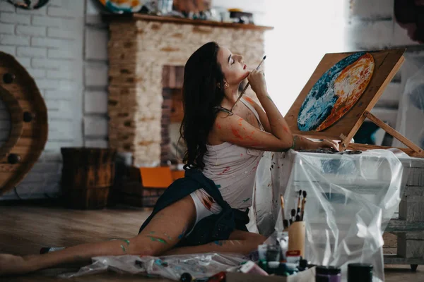 El artista dibuja un cuadro en un taller de arte . — Foto de Stock