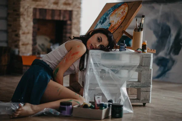 Der Künstler sitzt auf dem Boden in einer Kunstwerkstatt. — Stockfoto