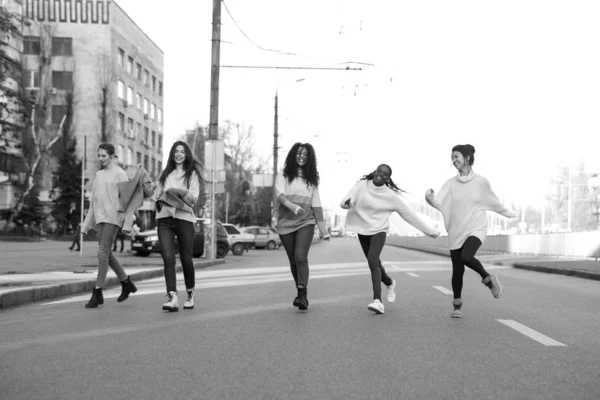Multiracial grupo de amigos corre y se divierte en la calle de la ciudad . — Foto de Stock