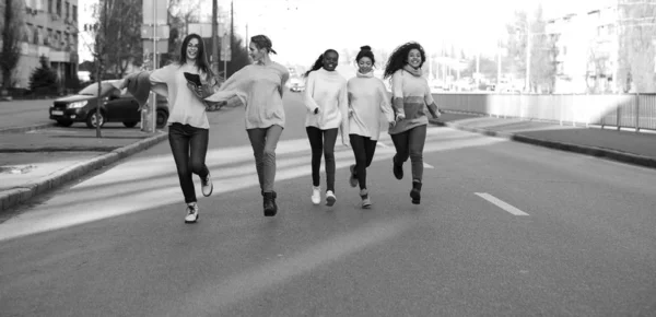 Multiracial grupp vänner kör och har en rolig på stadens gata. — Stockfoto