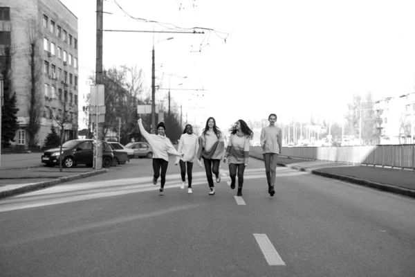 Multirazziale gruppo di amici corre e si diverte sulla strada della città . — Foto Stock