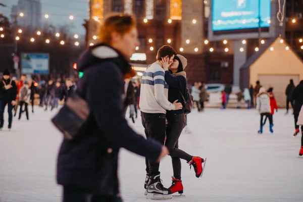 Young couple skates at the rink and kisses. — Stock Photo, Image
