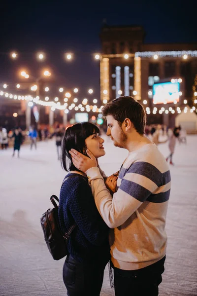 Casal jovem patina na pista e abraça . — Fotografia de Stock