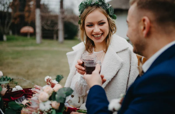 Recém Casados Sentam Perto Mesa Banquete Sorriem Colam Copos Vinho — Fotografia de Stock