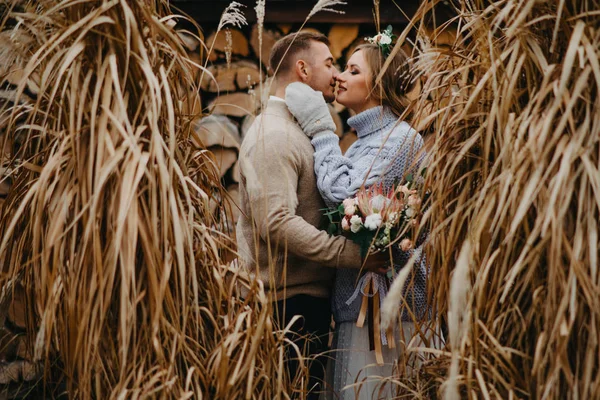 Newlyweds Stand Dry Grass Background Firewood Stack Embrace — Stock Photo, Image