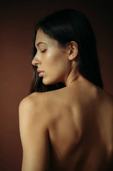 一个年轻女子的肖像 在工作室有一个裸露的背影 背景色 — 图库照片