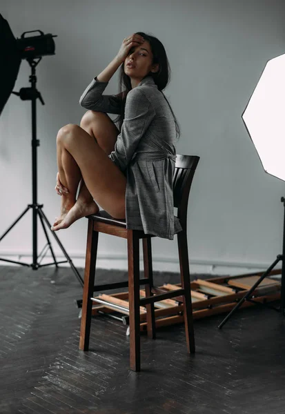 Mujer Joven Posando Estudio Fotografía Sentada Silla Junto Equipo Iluminación —  Fotos de Stock