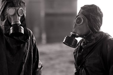 NBC koruyucu giysiler ve gaz maskeleri takan iki kişi. Koronavirüs COVID için önleyici önlemler ve koruma kavramı 19 salgın hastalık ve diğer küresel tehlikeler.
