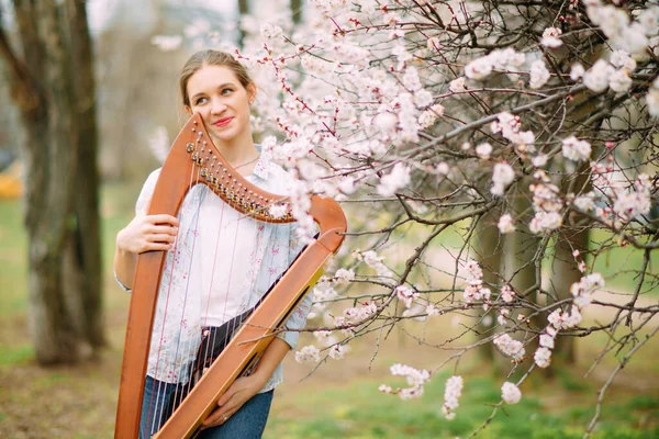 Žena Harfeník Těší Relaxovat Kvetoucí Zahradě Hraje Harfu Mezi Kvetoucími — Stock fotografie