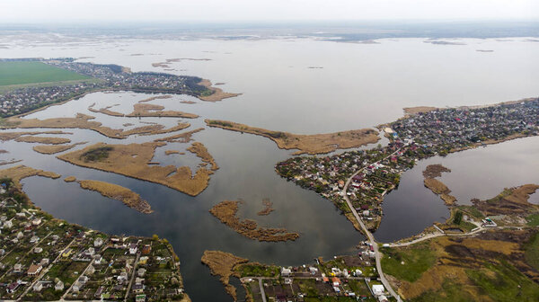 Вид с высоты птичьего полета на деревню, улицы, дороги, острова и дельту реки на горизонте. Стрельба дронами
.