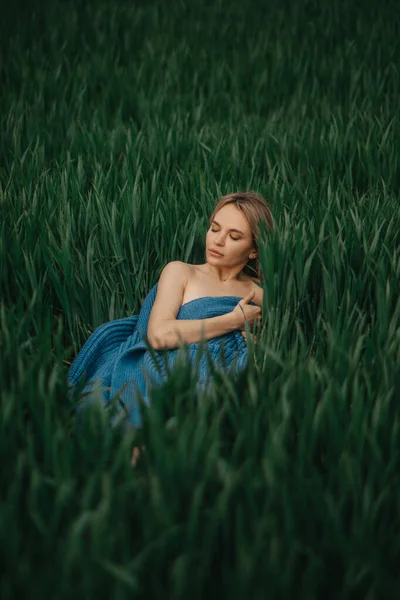 青いジャケットを着た若い女性は 緑の小麦の間に横になり リラックスし 休んでいます トップ表示 — ストック写真