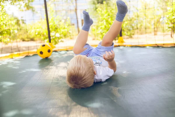 Bir topla oynamayı çocuk bir trambolin üzerinde atlama