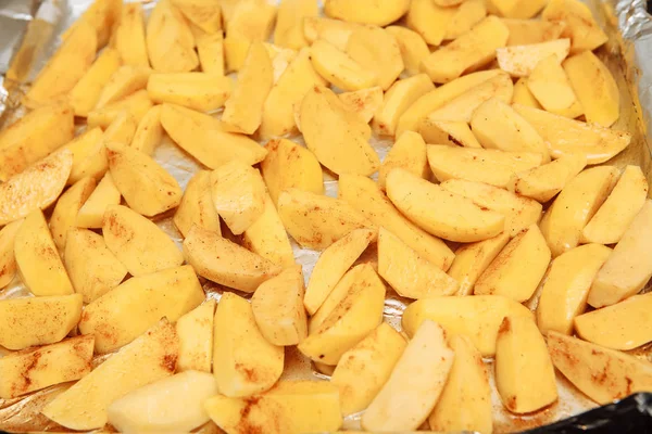 Tranches de pommes de terre crues sur une plaque à pâtisserie — Photo