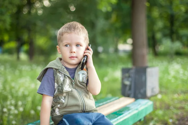 Malý chlapec mluvil po telefonu při posezení venku — Stock fotografie