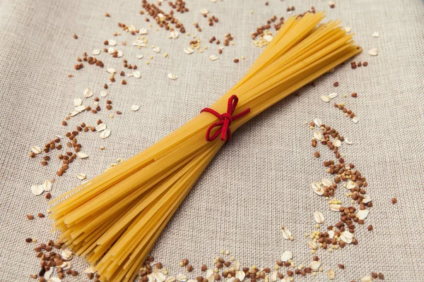 Arka plan duvar kağıdı, makarna spagetti, krup, buğday, pirinç, yulaf, Mısır gevreği, kumaş üzerine dağılmış.