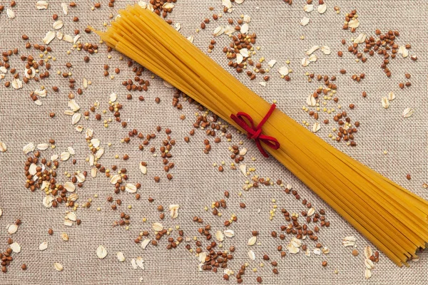 Arka plan duvar kağıdı, makarna spagetti, krup, buğday, pirinç, yulaf, Mısır gevreği, kumaş üzerine dağılmış.