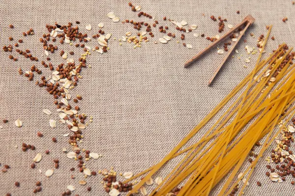 Arka plan duvar kağıdı, makarna spagetti, krup, buğday, pirinç, yulaf, Mısır gevreği, kumaş üzerine dağılmış.
