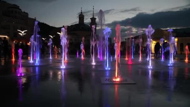 Вода, красочный фонтан, вечер, улица, люди — стоковое видео