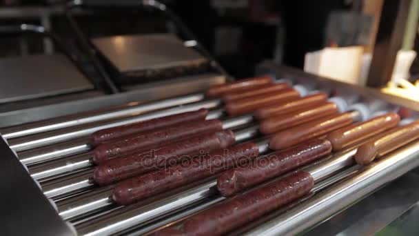 Korv grillning över lågorna. Aptitretande hotdog korvar som tillagas på grillen, snacks på street food festival. — Stockvideo