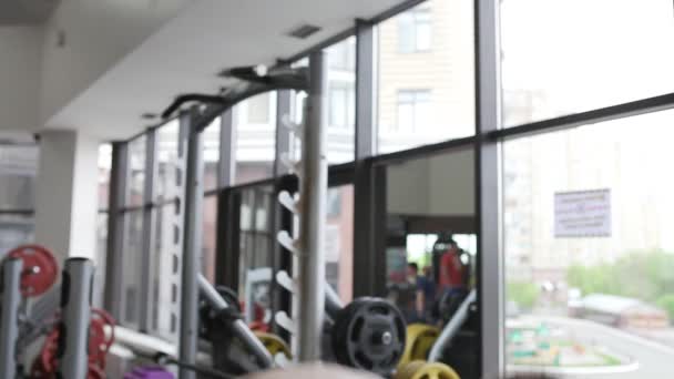 Un hombre está haciendo ejercicios de fuerza en el gimnasio. El tipo va a los deportes en un club deportivo . — Vídeos de Stock