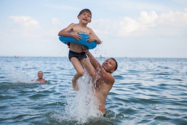 Baba ve oğlu denizde banyo, eğlenceli oyun.