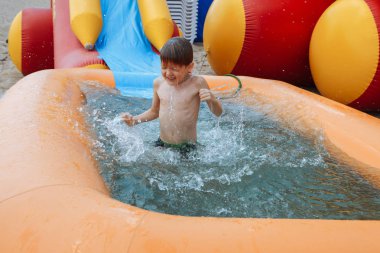 Küçük bir çocuk mutlu bir şişme havuzda boğulmuş olduğunu.