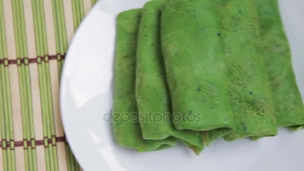 Dazu gibt es grüne Pfannkuchen mit Spinat. Spinat-Pfannkuchen, gefaltet auf einem Teller Nahaufnahme. Spinat grüne Pfannkuchen. — Stockvideo