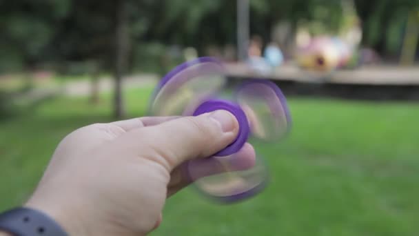 Um brinquedo infantil é um girador na mão de um adulto . — Vídeo de Stock