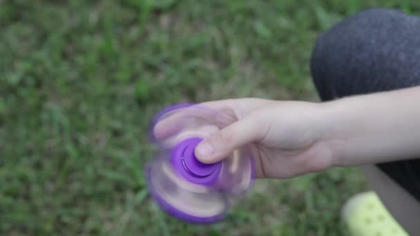 Barnens leksak spinner. Pojken spelar en spinnare på gatan. Leksak spinner i hand. — Stockvideo
